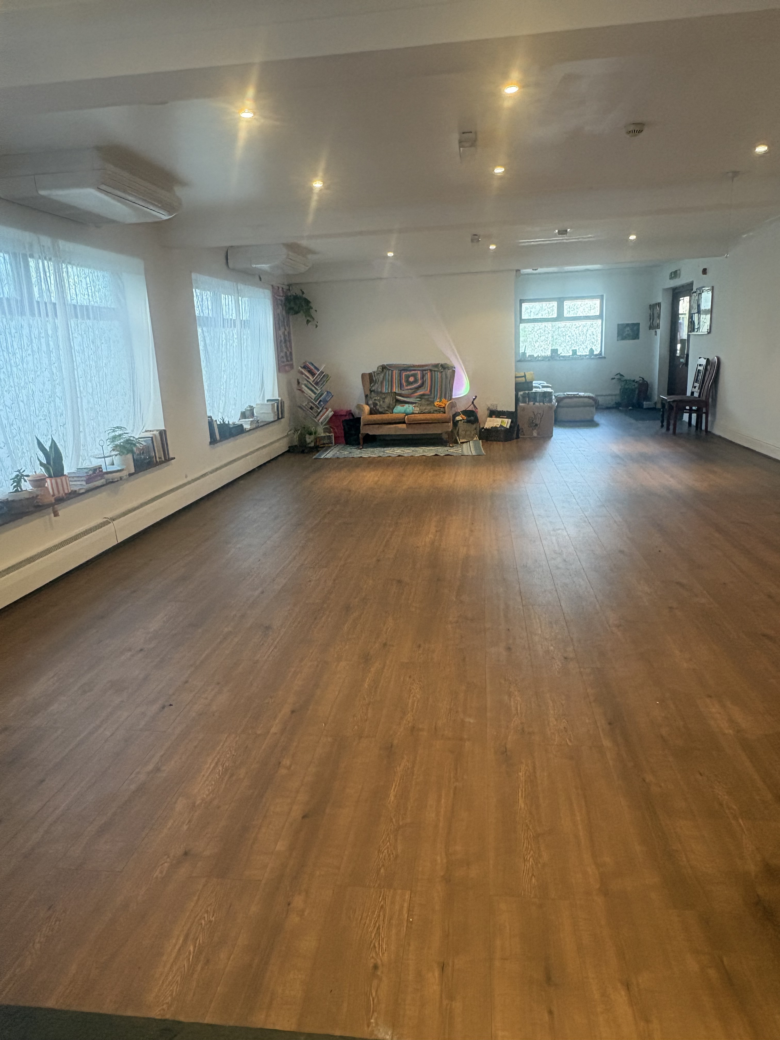 Large bright open studio with a wooden floor, wide windows and flexible space for group activities